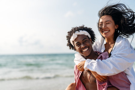 Romantic interracial couple enjoying a tropical honeymoon on a beach, embracing love and happinessの写真素材