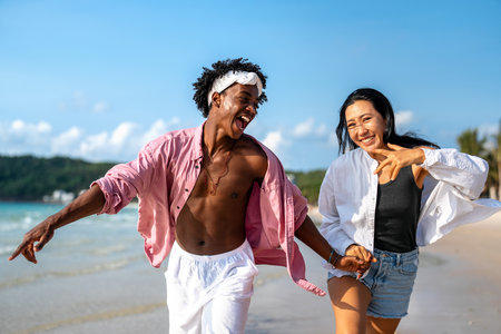 Interracial couple enjoying a romantic beach getaway, embracing love, laughter, and togethernessの写真素材