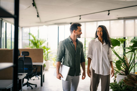 Two happy diverse multiethnic business team people working, talking in corporate officeの写真素材