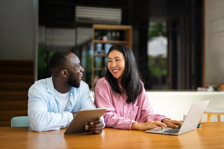 Happy multiethnic diverse couple, people using digital laptop for online shopping or payment.の写真素材