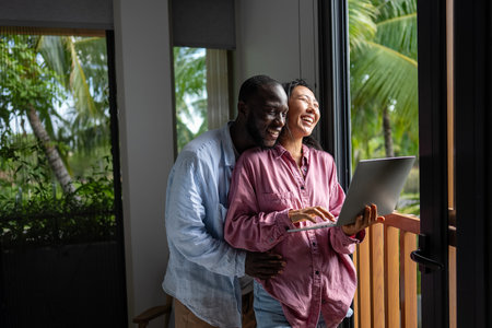 Multicultural couple working remotely, planning finances and investments online. Digital lifestyleの写真素材