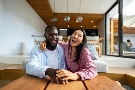 Young diverse multiethnic couple in new home. Couple is having fun in new house at moving dayの写真素材
