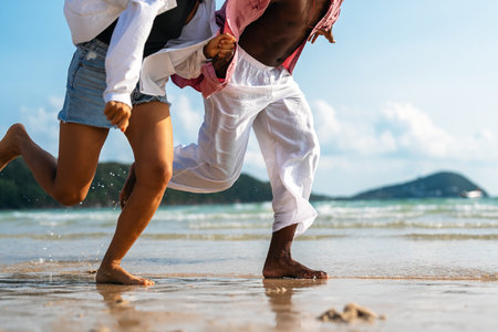 Passionate summer love on a tropical beach, young interracial couple enjoying adventure, laughterの写真素材