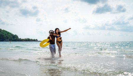 Carefree couple enjoying a tropical beach vacation, laughing making unforgettable memories togetherの写真素材