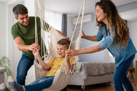 Family from three people cheerfully spends fun time at home together. Parents, kid happiness conceptの写真素材