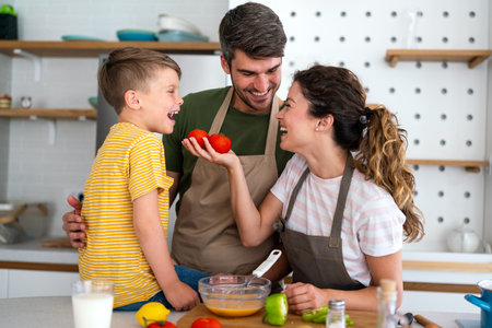 Mother and father making breakfast with son. Young family preparing delicious food in kitchenの写真素材