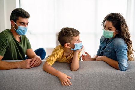 Beautiful young family wearing face masks against coronavirus, pollution, disease and staying homeの写真素材