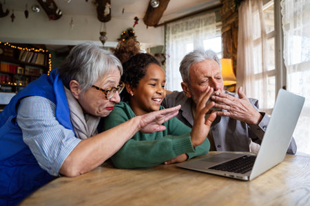 Mature couple with grandchild look at laptop screen and learn how to make video call or use laptop