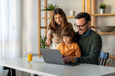Happy single parent with cute excited small kid son using laptop computer at home. Technologyの写真素材