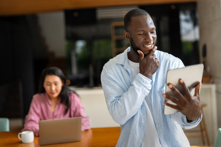 Couple of freelance IT specialists using digital technology devices while working remotely from home