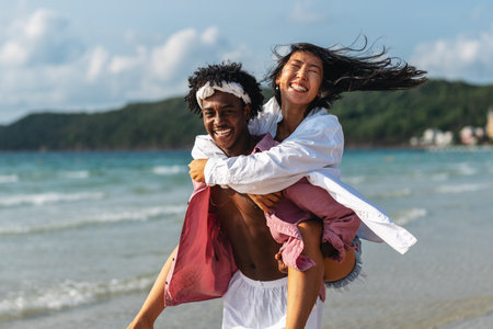 Romantic interracial couple enjoying a tropical honeymoon on a beach, embracing love and happinessの写真素材