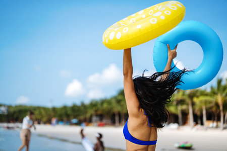Excited young woman enjoying her tropical beach vacation and celebrating a fun-filled summer getaway