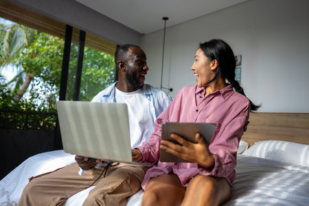 Multicultural couple working remotely, planning finances and investments online. Digital lifestyleの写真素材