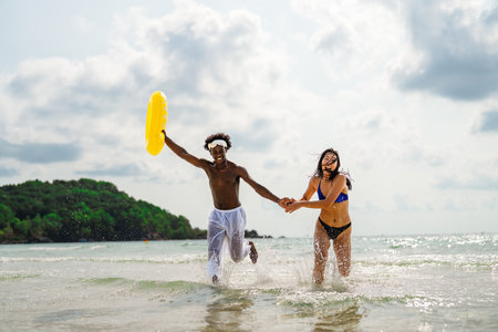 Interracial couple enjoying a romantic beach getaway, embracing love, laughter, and togethernessの写真素材