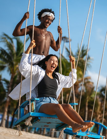 Passionate summer love on a tropical beach, young interracial couple enjoying adventure, laughterの写真素材