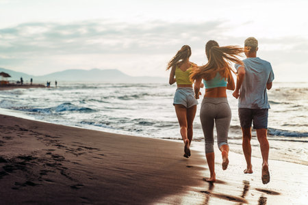 Group running on beach jogging having fun training. Exercising runners training outdoorsの写真素材