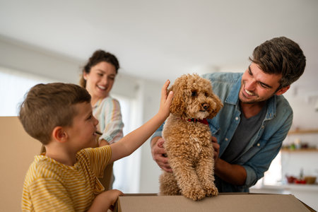 Happy family with cardboard boxes in new house at moving day.の写真素材