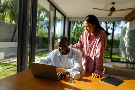 Young diverse multiethnic couple in new home. Couple is having fun in new house at moving dayの写真素材