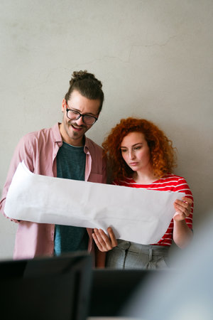 Happy businesspeople laughing while collaborating on a new project in an office. Business startup.の写真素材