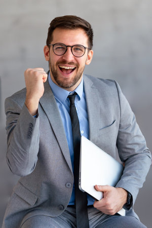 Young happy successful young businessman working and smiling at corporate officeの写真素材