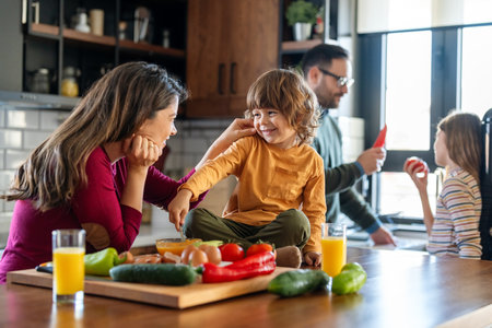 Happy family is cooking together in a bright kitchen, showing joy, teamwork, and love at homeの写真素材