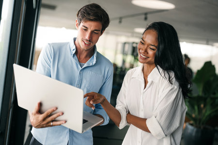 Two happy diverse multiethnic business team people working, talking in corporate officeの写真素材