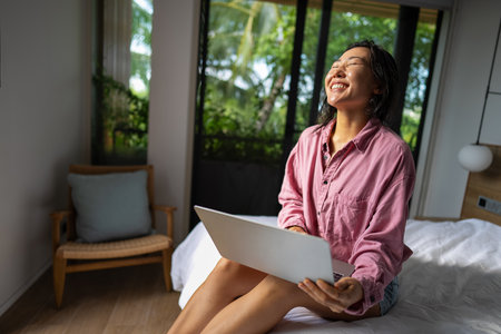 Asian woman using her laptop for remote freelance work, the freedom of a digital nomad lifestyleの写真素材
