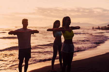 Portrait of a happy group of people exercising and doing sports and workout on the beachの写真素材