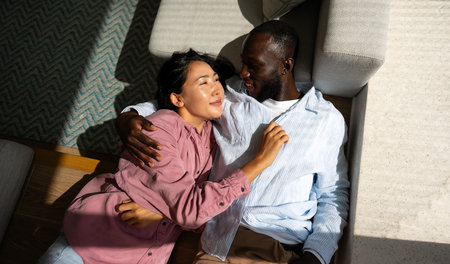 Interracial couple embracing celebrating love, diversity, and unity in a supportive relationshipの写真素材