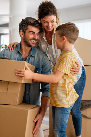 Moving, parents and child in new home bonding together, unpacking boxes for family timeの写真素材