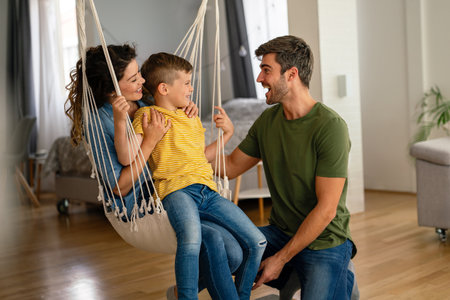 Happy multiethnic family having fun at home, parents and little child spending quality time togetherの写真素材