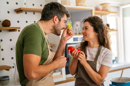 A young couple in love having good time while preparing a breakfast together on a beautiful morningの写真素材
