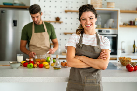 Happy couple enjoying cooking in the kitchen feeling happy and carefree on weekend lifestyle at homeの写真素材