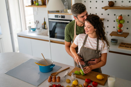 A young couple in love having good time while preparing a breakfast together on a beautiful morningの写真素材