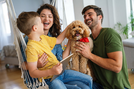 Happy family with kid having fun using tablet together, parents and child laughing relaxing at homeの写真素材