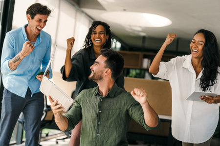 Joyful, excited diverse entrepreneurs are celebrating their success and the great work environment
