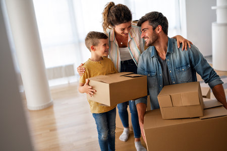 Happy family with cardboard boxes in new house at moving day. Mortgage, family, real estate concept