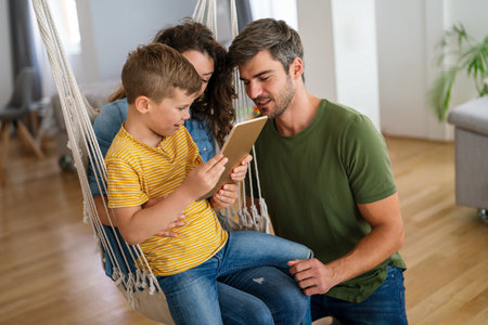 Happy family, parents with cute excited small kids son using laptop computer at home. Technologyの写真素材