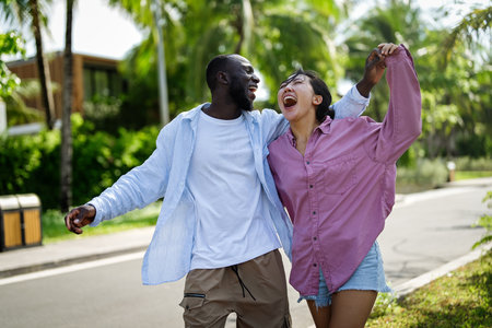 Happy interracial couple laughing together outdoors, enjoying a carefree moment of love, joyの写真素材