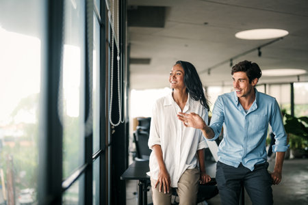 Two happy diverse multiethnic business team people working, talking in corporate officeの写真素材
