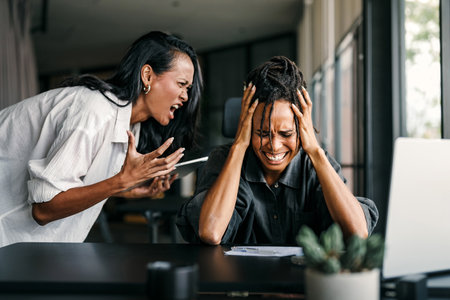 Stressful work environment, overtime. Frustrated boss yelling at his subordinate in the office
