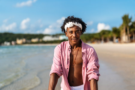 Happy man enjoying the sunshine and the beauty of the ocean for the perfect vacation escapeの写真素材
