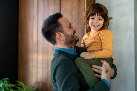 Affectionate single dad enjoy chatting with little son tell about passed day, having fun togetherの写真素材
