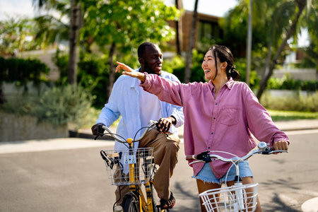 Interracial couple enjoying a joyful bike ride, celebrating love, diversity, and togethernessの写真素材