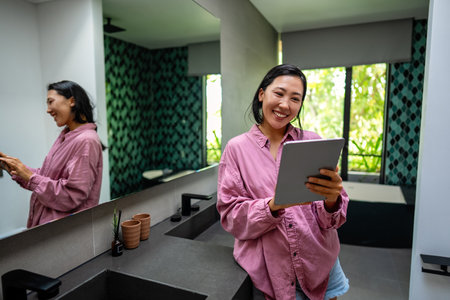 Happy asian freelance woman reading good feedback from his client on his project on a laptopの写真素材