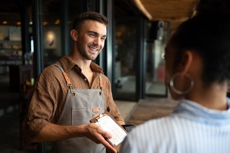 Passionate barista and business owner bringing warmth and quality service to his stylish coffee shopの写真素材