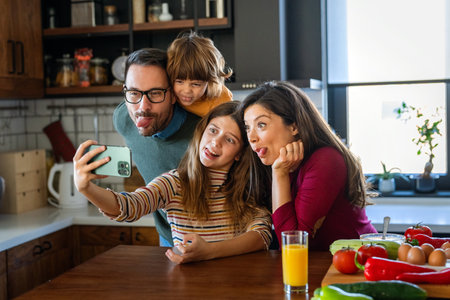 Happy parents with children using smartphone together at home. Family watching video having fun