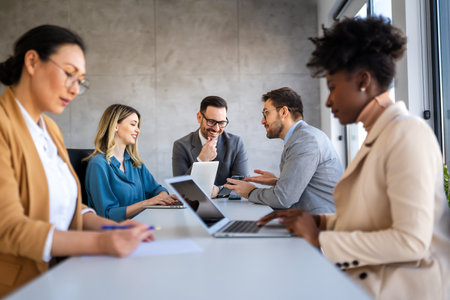 Multicultural professional businesspeople working together on research plan in boardroom.の写真素材