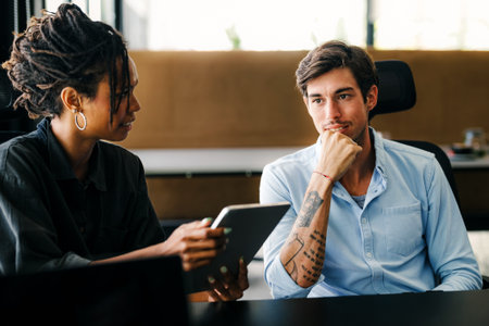 Two happy diverse multiethnic business team people working, talking in corporate officeの写真素材