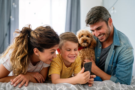 Family from three people cheerfully spends fun time at home together. Parents, kid happiness conceptの写真素材